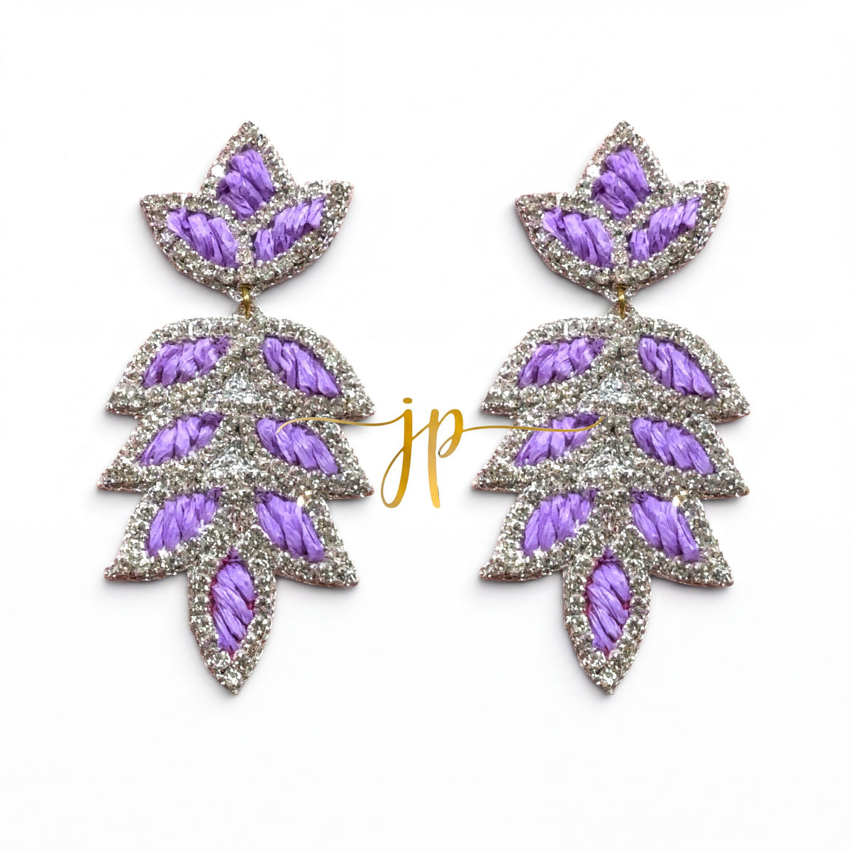 A pair of earrings with purple and silver leaf-shaped designs, featuring a combination of embroidered and metallic elements.