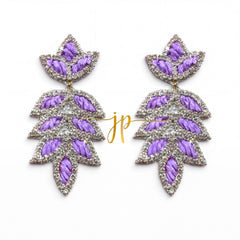 A pair of earrings with purple and silver leaf-shaped designs, featuring a combination of embroidered and metallic elements.